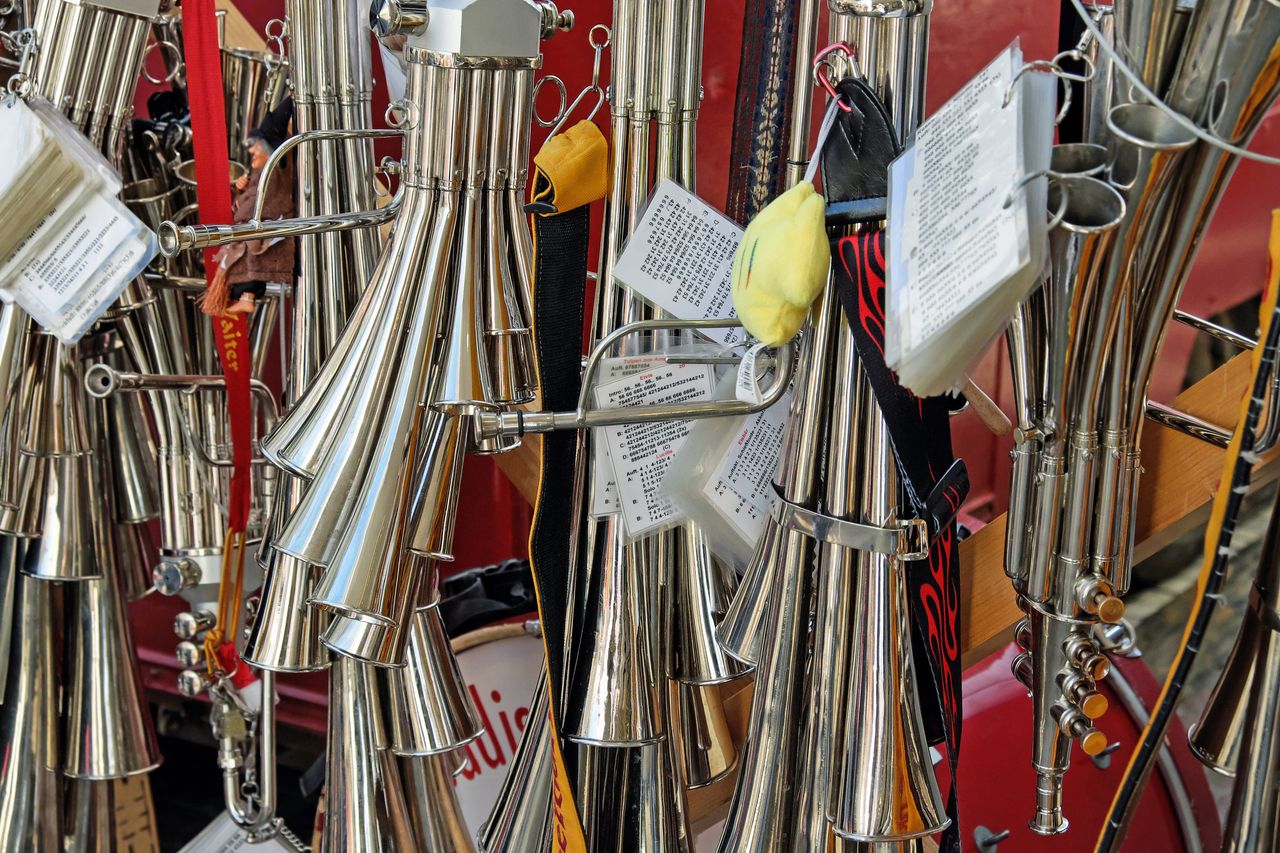A detailed view of traditional brass musical instruments hanging in a display.